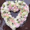 a heart shaped flower arrangement on wet surface
