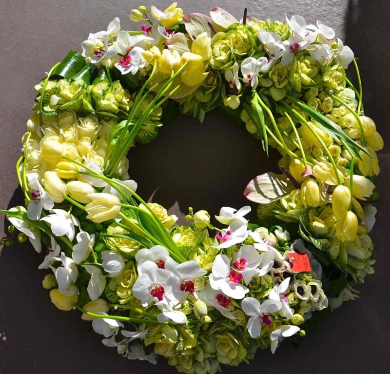 a wreath of flowers on a black surface