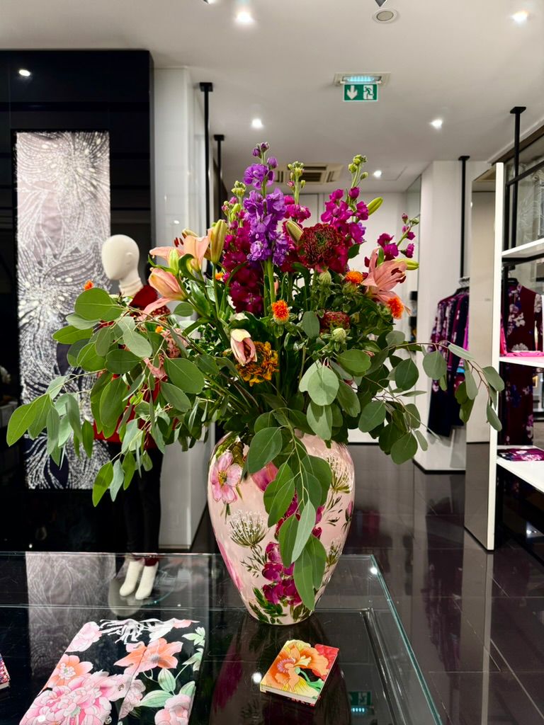 Large indoor floral arrangement with magenta accents.